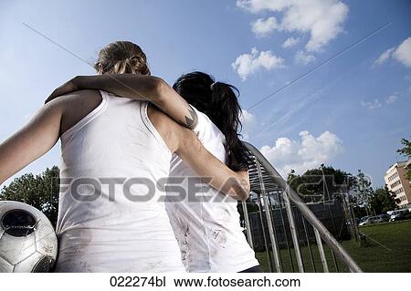 rear view of two female football players embracing View Large Photo Image Stock Image - rear view of two female football players embracing. Fotosearch