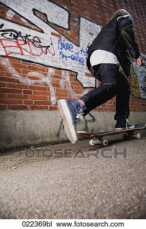 rear view of young boy skateboarding along wall View Large Photo Image Stock Image - rear view of young boy skateboarding along wall. Fotosearch