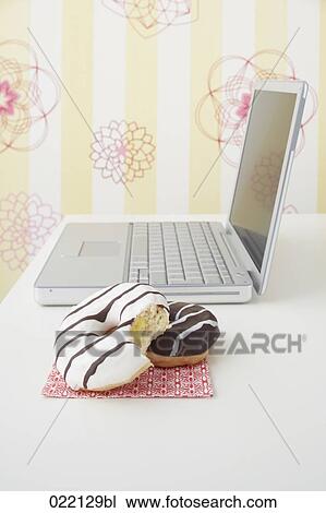still life of donuts and laptop on table View Large Photo Image Stock Image - still life of donuts and laptop on table. Fotosearch