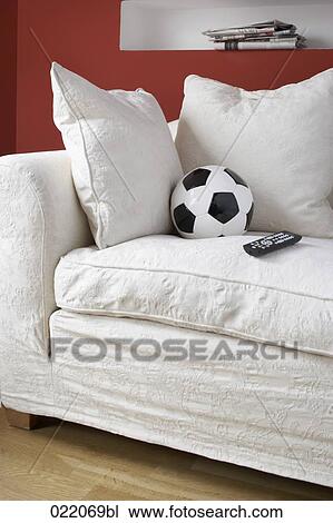 still life of football and remote control on sofa View Large Photo Image Stock Image - still life of football and remote control on sofa. Fotosearch