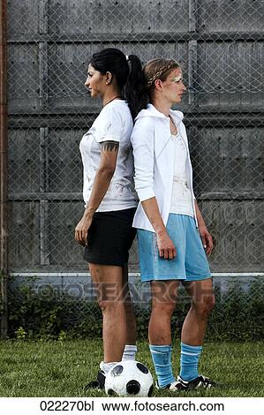 two female football players standing back to back View Large Photo Image Stock Image - two female football players standing back to back. Fotosearch