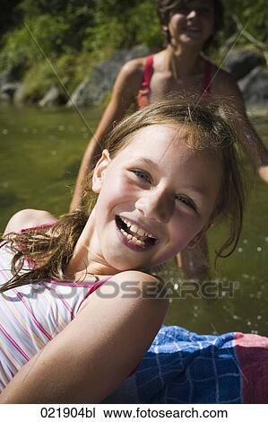 two little sisters relaxing by the river View Large Photo Image Stock Image - two little sisters relaxing by the river. Fotosearch