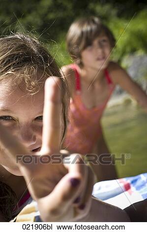 two little sisters relaxing by the river View Large Photo Image Stock Image - two little sisters relaxing by the river. Fotosearch