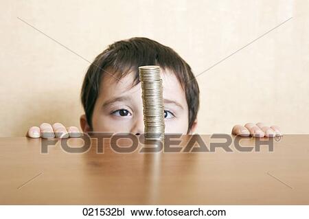 young boy behind table looking at pile of coins View Large Photo Image Stock Image - young boy behind table looking at pile of coins. Fotosearch