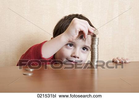 Stock Image - young boy making pile of coins. Fotosearch