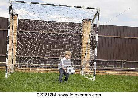 young boy standing in football goal catching ball View Large Photo Image Stock Image - young boy standing in football goal catching ball. Fotosearch