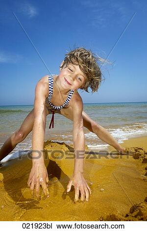 young girl on beach playing with sand View Large Photo Image Stock Image - young girl on beach playing with sand. Fotosearch