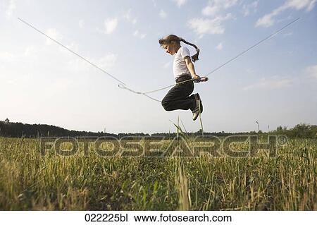 young girl skipping in field View Large Photo Image Stock Image - young girl skipping in field. Fotosearch