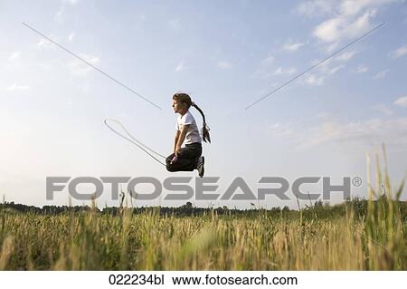 young girl skipping in field View Large Photo Image Stock Image - young girl skipping in field. Fotosearch