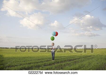 young girl standing in field letting ballons fly View Large Photo Image Stock Image - young girl standing in field letting ballons fly. Fotosearch