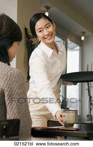 young japanese waitress serving guest at restaurant View Large Photo Image Stock Image - young japanese waitress serving guest at restaurant. Fotosearch