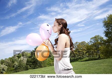 young woman in park kissing balloon View Large Photo Image Stock Image - young woman in park kissing balloon. Fotosearch