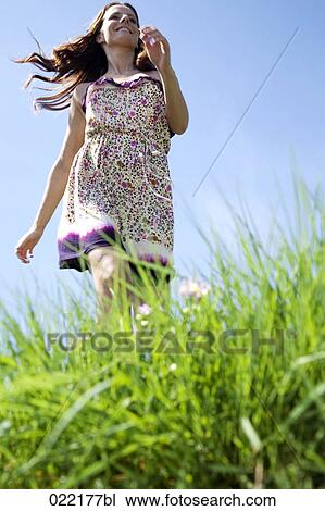 young woman running through grass in park View Large Photo Image Stock Image - young woman running through grass in park. Fotosearch