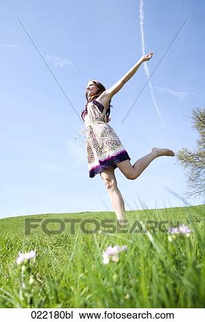 young woman running through grass in park View Large Photo Image Stock Image - young woman running through grass in park. Fotosearch