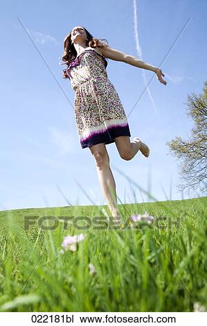 young woman running through grass in park View Large Photo Image Stock Image - young woman running through grass in park. Fotosearch