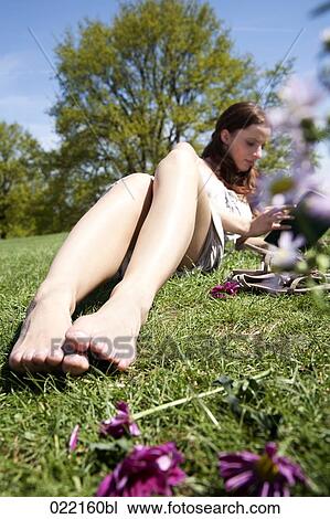 young woman sitting in grass reading book View Large Photo Image Stock Image - young woman sitting in grass reading book. Fotosearch
