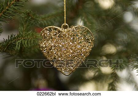 Stock Image - decoration in shape of heart hanging on christmas tree. Fotosearch