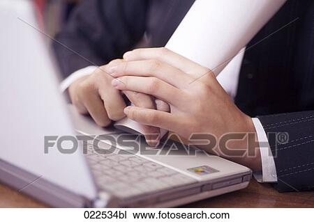 detail of young businesswoman sitting at desk in front of laptop computer View Large Photo Image Stock Image - detail of young businesswoman sitting at desk in front of laptop computer. Fotosearch