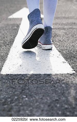 detail of young girl standing on arrow sign on road View Large Photo Image Stock Image - detail of young girl standing on arrow sign on road. Fotosearch