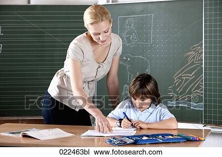 female teacher helping young pupil at school View Large Photo Image Stock Image - female teacher helping young pupil at school. Fotosearch