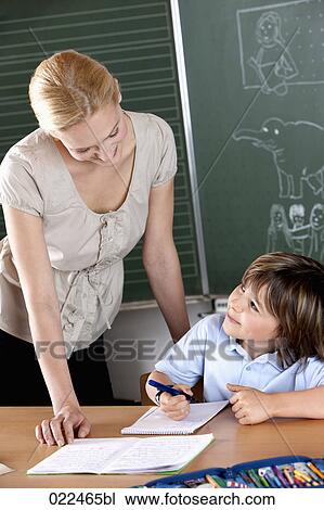 female teacher helping young pupil at school View Large Photo Image Stock Image - female teacher helping young pupil at school. Fotosearch