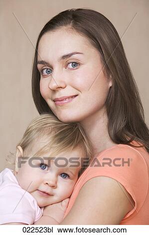 Stock Image - headshot of young mother with baby daughter. Fotosearch