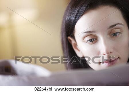 headshot of young woman reading newspaper View Large Photo Image Stock Image - headshot of young woman reading newspaper. Fotosearch
