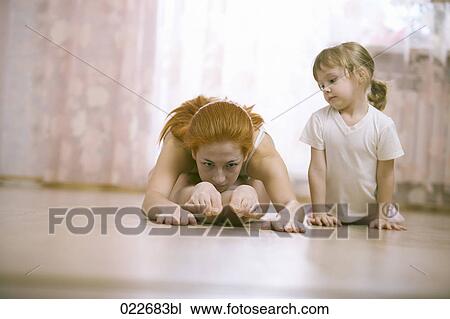 little girl watching her mother doing stretching exercises View Large Photo Image Stock Image - little girl watching her mother doing stretching exercises. Fotosearch