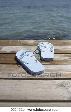 pair of flip flops on wooden pier in front of the ocean View Large Photo Image Stock Image - pair of flip flops on wooden pier in front of the ocean. Fotosearch