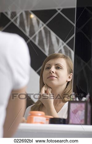 poritrait of young woman applying make-up View Large Photo Image Stock Image - poritrait of young woman applying make-up. Fotosearch