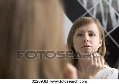 poritrait of young woman applying make-up View Large Photo Image Stock Image - poritrait of young woman applying make-up. Fotosearch