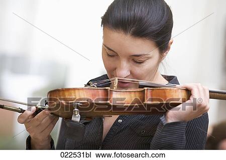 Stock Image - portrait of female violinist kissing her instrument. Fotosearch