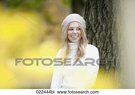 Stock Image - portrait of teenage girl leaning against tree. Fotosearch