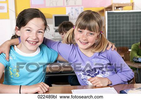 portrait of two young girls in classroom embracing View Large Photo Image Stock Image - portrait of two young girls in classroom embracing. Fotosearch