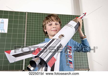 portrait of young boy in classroom holding model of rocket View Large Photo Image Stock Image - portrait of young boy in classroom holding model of rocket. Fotosearch