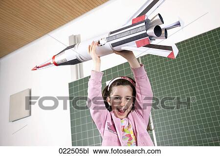 portrait of young girl in classroom holding model of rocket View Large Photo Image Stock Image - portrait of young girl in classroom holding model of rocket. Fotosearch