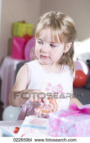 portrait of young girl with cupcake at birthday party View Large Photo Image Stock Image - portrait of young girl with cupcake at birthday party. Fotosearch