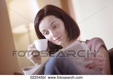 portrait of young woman at home reading newspaper and drinking coffee View Large Photo Image Stock Image - portrait of young woman at home reading newspaper and drinking coffee. Fotosearch