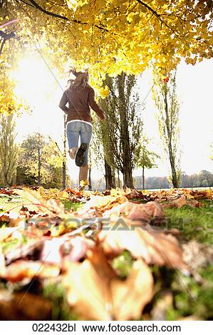 rear view of teenage girl running through park in autumn View Large Photo Image Stock Image - rear view of teenage girl running through park in autumn. Fotosearch