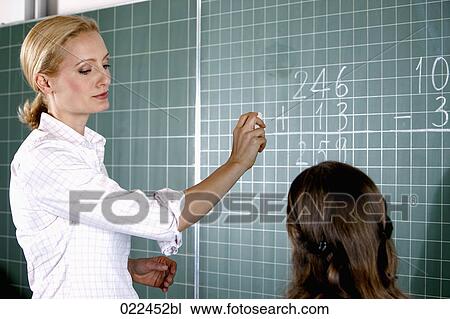 teacher and young girl in front of blackboard in classroom View Large Photo Image Stock Image - teacher and young girl in front of blackboard in classroom. Fotosearch
