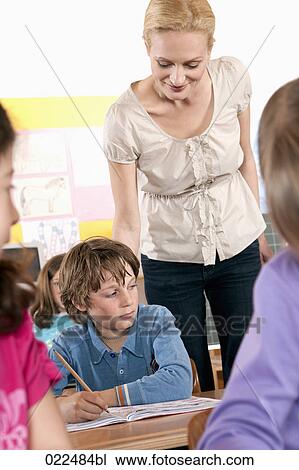 teacher checking work of young boy in classroom View Large Photo Image Stock Image - teacher checking work of young boy in classroom. Fotosearch