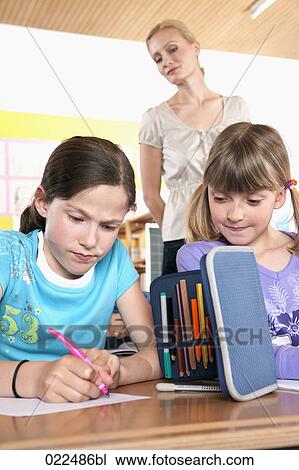 teacher watching two young girls writing test View Large Photo Image Stock Image - teacher watching two young girls writing test. Fotosearch