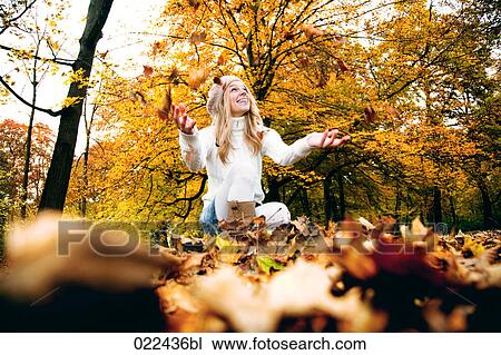 teenage girl in park playing with autumn leaves View Large Photo Image Stock Image - teenage girl in park playing with autumn leaves. Fotosearch