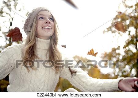 teenage girl in park playing with autumn leaves View Large Photo Image Stock Image - teenage girl in park playing with autumn leaves. Fotosearch