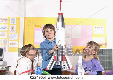 young boy in classroom holding model of rocket View Large Photo Image Stock Image - young boy in classroom holding model of rocket. Fotosearch