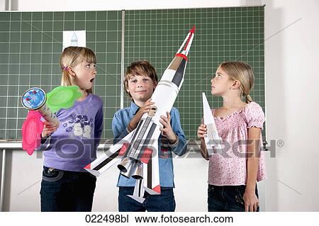 young boy in classroom holding model of rocket View Large Photo Image Stock Image - young boy in classroom holding model of rocket. Fotosearch