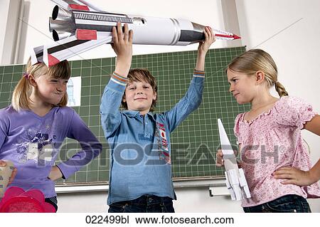 young boy in classroom holding model of rocket View Large Photo Image Stock Image - young boy in classroom holding model of rocket. Fotosearch