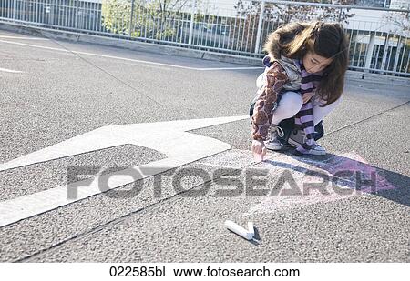 young girl drawing arrow in opposite direction of road sign View Large Photo Image Stock Image - young girl drawing arrow in opposite direction of road sign. Fotosearch