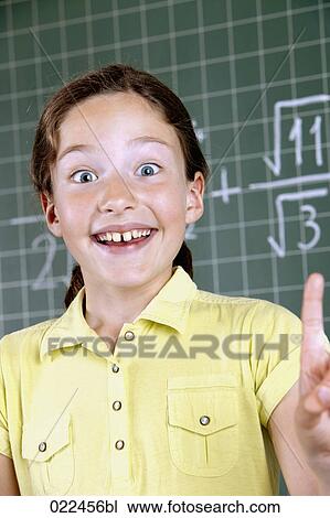 Stock Image - young girl in front of blackboard having idea. Fotosearch