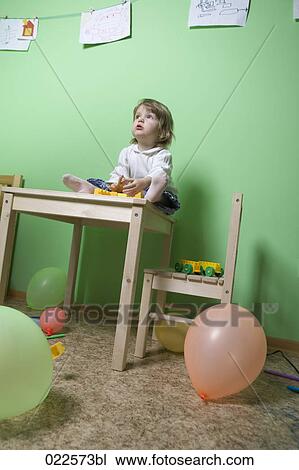 young girl sitting on table in children´s room View Large Photo Image Stock Image - young girl sitting on table in children´s room. Fotosearch
